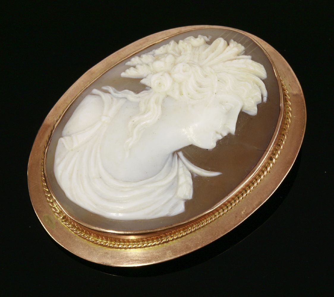 An Edwardian carved shell cameo gold brooch, circa 1910, with the profile of Flora in white to a