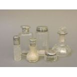 Six silver topped glass scent bottles and jars, tallest 9cm