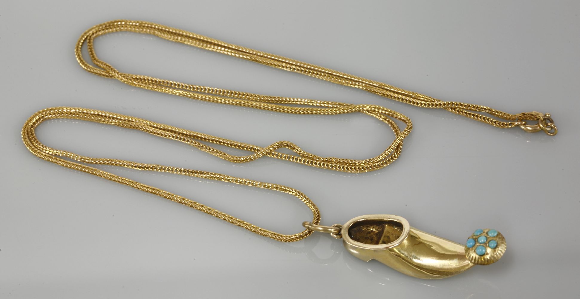 A gold shoe pendant, tested as approximately 14ct gold, set with turquoise coloured stones on a