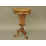 A Victorian walnut octagonal work table, inlaid top opening to reveal fitted interior over fluted