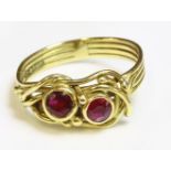 An 18ct gold two stone ruby ring by Susan Wright, with two circular mixed cut rubies rub set in