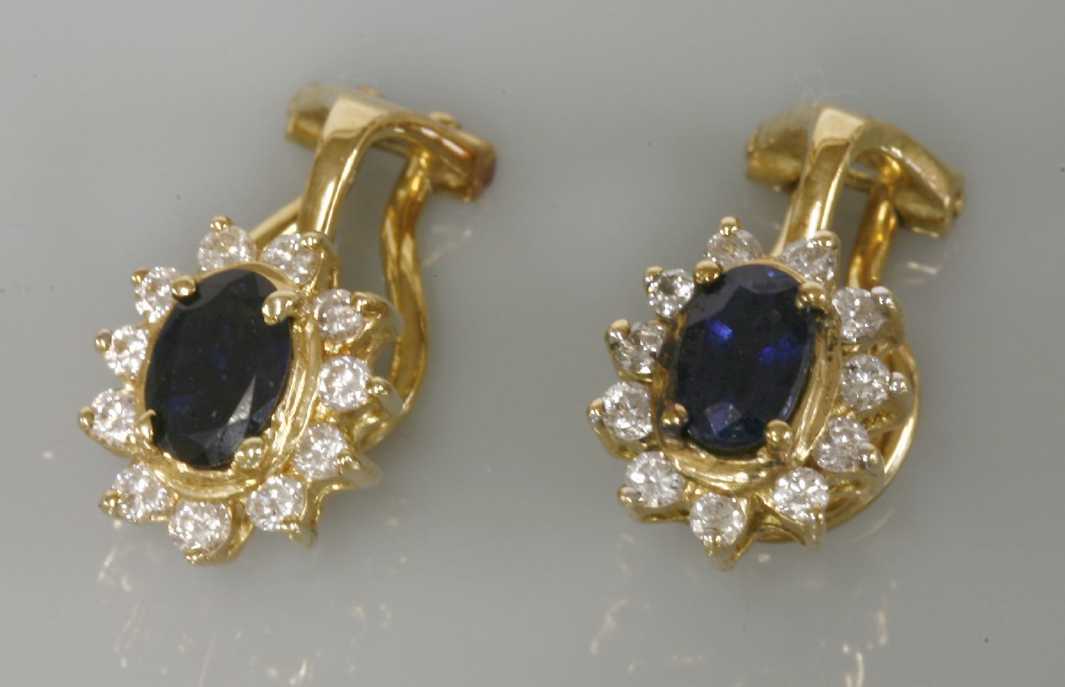 A pair of 18ct gold sapphire and diamond oval cluster clip on earrings, easily converted to