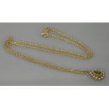 An Edwardian peridot and split pearl pendant, marked 15ct, on a 9ct gold chain