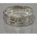 A silver bangle, in the form of a buckle