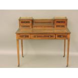 An Edwardian satin wood cross banded desk, by Jas Shoolbred & Co, having a short pierced brass