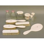 A dressing table set, including four ivory mounted brushes, a looking glass, four bottles with ivory