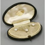 A cased set of three pearl set gold dress studs, all marked 18ct, in a case by J C Vickery, pearls