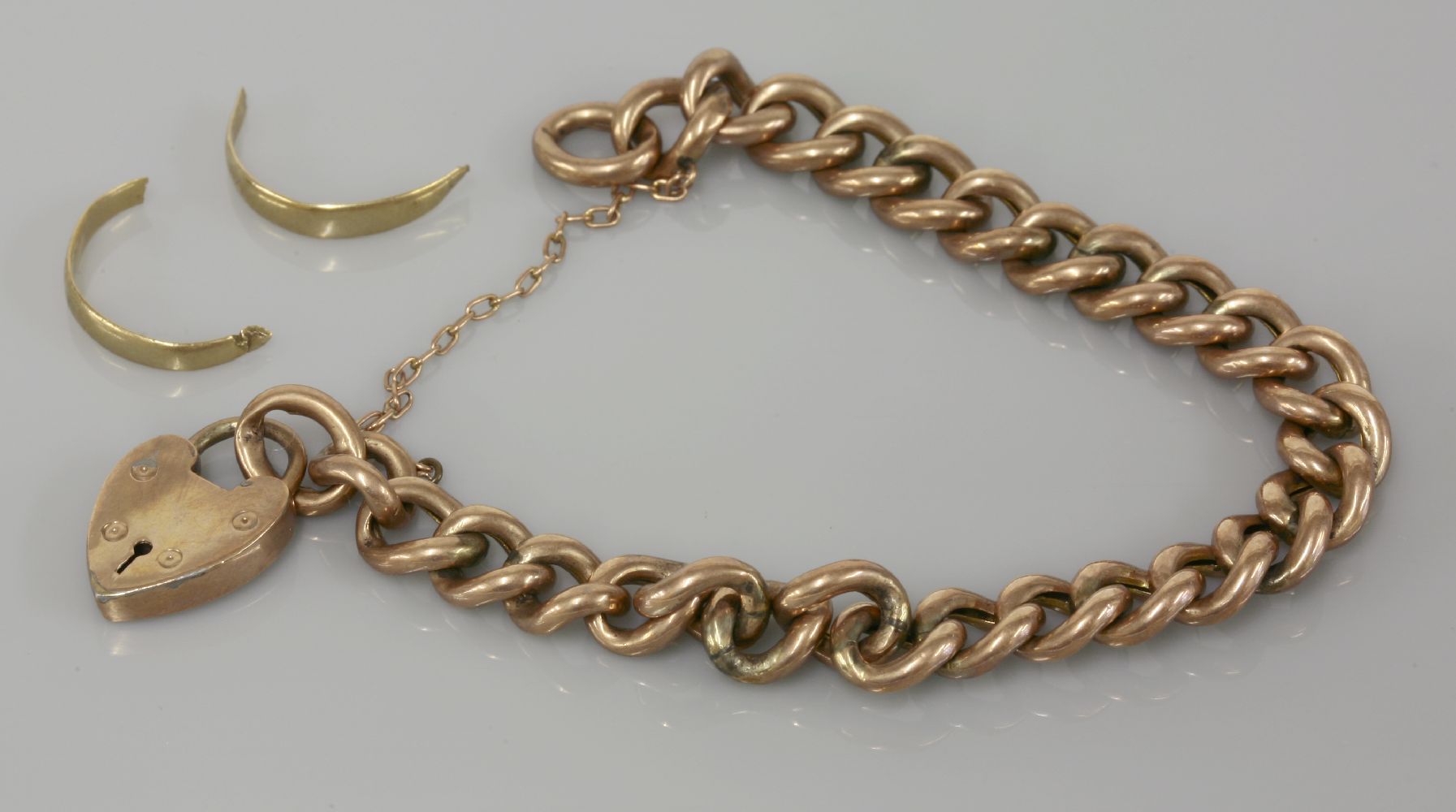 A gold hollow curb link chain bracelet, tested as approximately 9ct gold, and a 9ct gold wedding