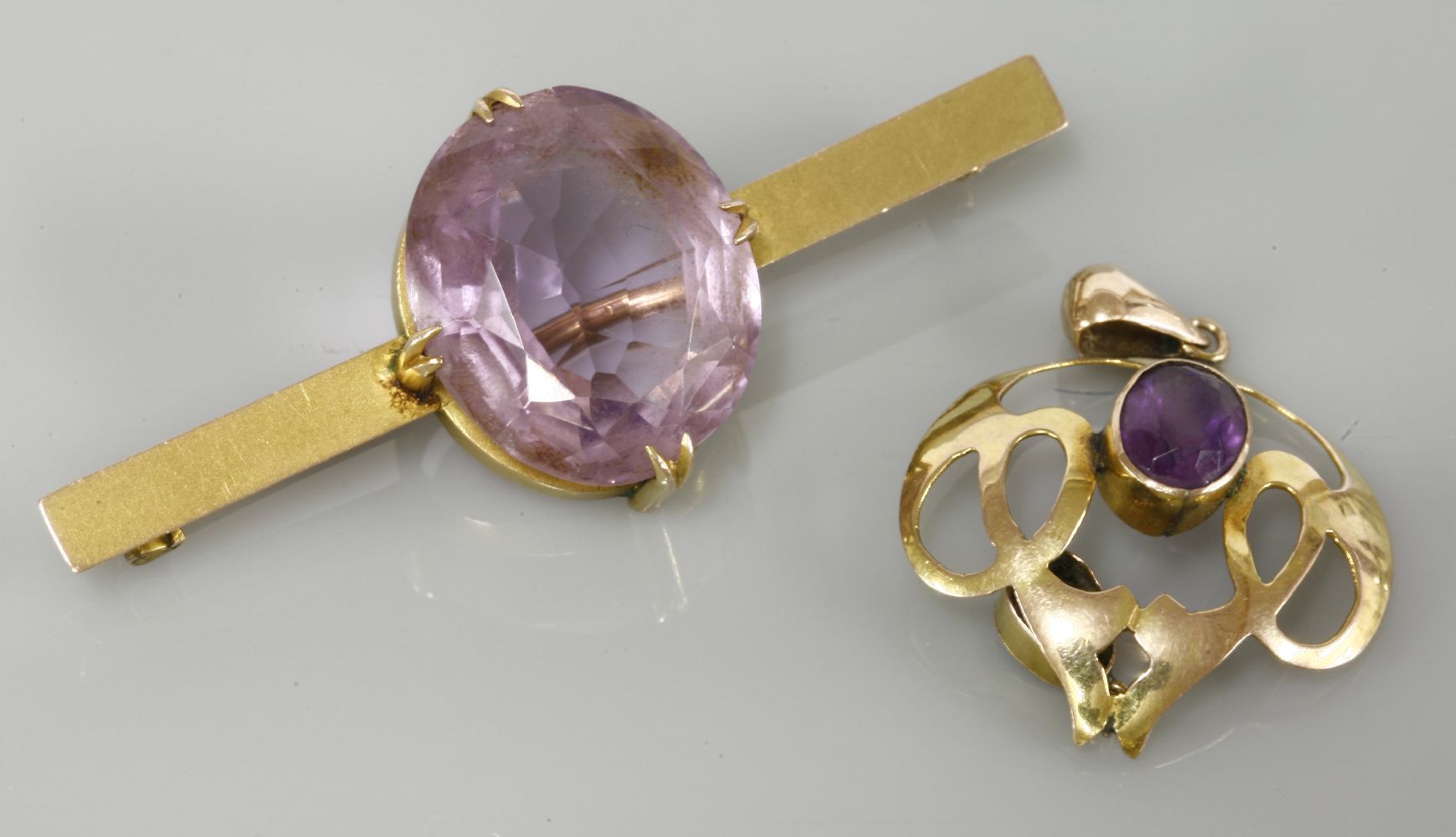 An Art Nouveau gold amethyst pendant, and an amethyst bar brooch marked 9ct