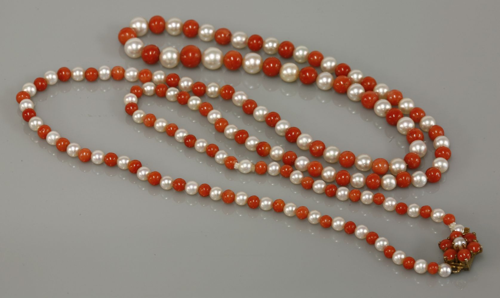 A single row graduated cultured pearl and coral necklace, with a 9ct gold cultured pearl and coral