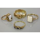 A 9ct gold garnet set buckle ring, a single stone opal ring marked 9ct, a boat shaped ring set