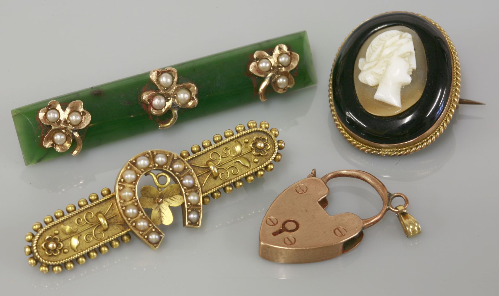 An Etruscan style split pearl gold bar brooch, marked 15ct, a nephrite jade split pearl gold bar