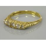 An 18ct gold five stone diamond set carved head ring