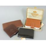 A brown leather wallet, a black leather wallet by ‘The Craftsman’, an oxblood leather cigarette box,