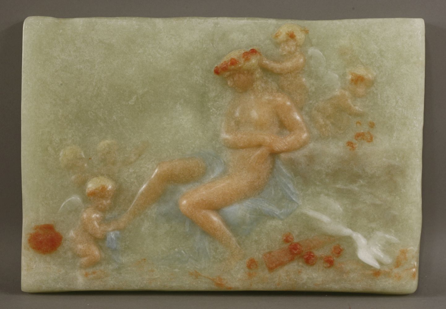 A large and rare pâte-de-verre plaque,in the manner of Despret, modelled as putti washing the feet