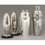 A pair of chrome cigar-shaped cocktail shakers,detachable, on ebonised plinths,20cm high, andtwo