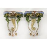A pair of Continental glazed wall brackets,each modelled as a cornucopia of fruit with polychrome
