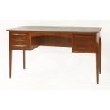 A Danish teak desk,with a chamfered top and three drawers either side, the reverse with a long