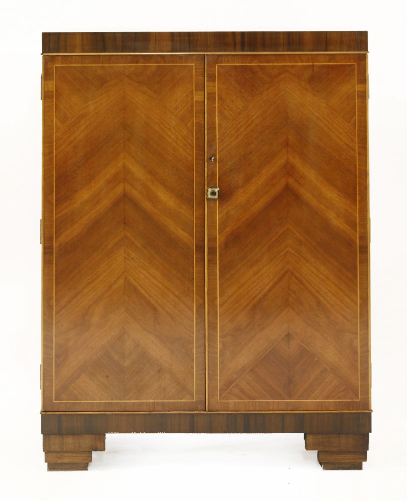 An Art Deco walnut and rosewood bar,the top hinged and opening to reveal a mirror, over shelves