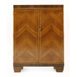 An Art Deco walnut and rosewood bar,the top hinged and opening to reveal a mirror, over shelves