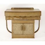 An Art Deco limed oak side cabinet,with a slight bow front, three drawers over a cupboard on a 'U'