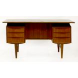 A Danish teak desk,with a floating top, with three drawers either side, the reverse with a