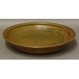 *A stoneware dish,by Michael Casson (1925-2003), with a treacle/orange glaze, impressed seal mark,