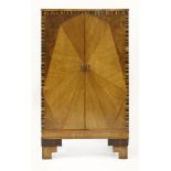 An Art Deco walnut and rosewood strung cabinet,enclosing three shelves raised on stepped block