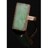 An 18ct gold jade ring,by Bernard Instone, with a rectangular curved jade plaque, rub set to a