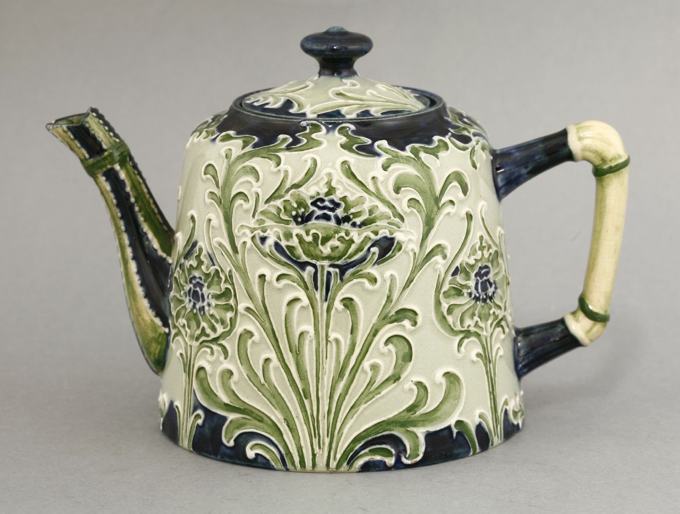 A MacIntryre 'Florianware' teapot,tube lined with flower heads in shades of green, blue and