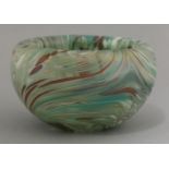 A French art glass bowl, late 19th century, decorated with swirls of red, blue, white and green,