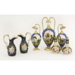 A garniture of blue ground Vases,early 19th century, each decorated with a shaped landscape panel