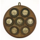 A mahogany plaque,mounted with seven circular coloured mezzotints of naval battles,37cm diameter