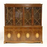 A George III style yew wood bookcase, with glazed upper section over cupboards beneath