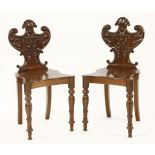 A pair of mahogany hall chairs, with scrolled backs, centred with a bust, restored, cleaned