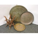 An engraved copper dished tray, on folding wood stand, and an Islamic silver and brass salver