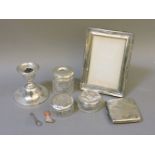 Assorted silver, comprising a candlestick, three silver topped dressing table jars, a photograph