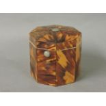 A tortoiseshell octagonal tea caddy, with a silver button top and an internal cover, marbled paper