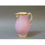 A Coalport Salopian ware jug, with a pink ground, mask, spout and handle, 15.5cm high