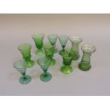 A set of six green glass goblets, etched with fruit, a further set of four glasses, and a pair of