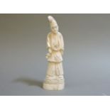A Japanese walrus ivory shinto priest, his details carved and filled in black, 20cm