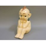 A Kewpie advertising stoneware figure, circa 1950, with polychrome glazed face and hair, stamped