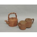 Two Chinese yixing teapots, one of square form with twisted bamboo handle and prunus finial, the