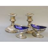 A pair of silver boat shape salts, and a pair of silver dwarf candlesticks