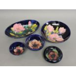Two Moorcroft 'Magnolia' bowls, 13cm and 18.5cm diameter, and three small bowls