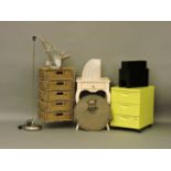 A wicker five drawer chest, a modern table, plastic magazine racks, a filing cabinet, two lamps, and