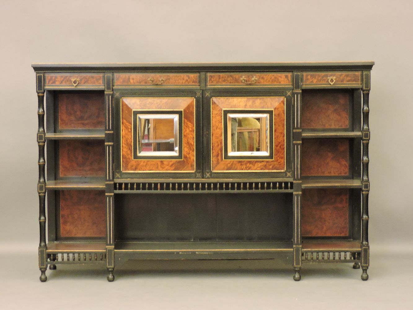A Victorian Aesthetic burr walnut and ebonised side cabinet, with mirrored doors, four drawers and