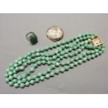 A three row Peking glass bead necklace, with gold clasp set with six jade beads to either side of