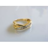 An 18ct gold channel set crossover diamond ring, 0.33ct approximately