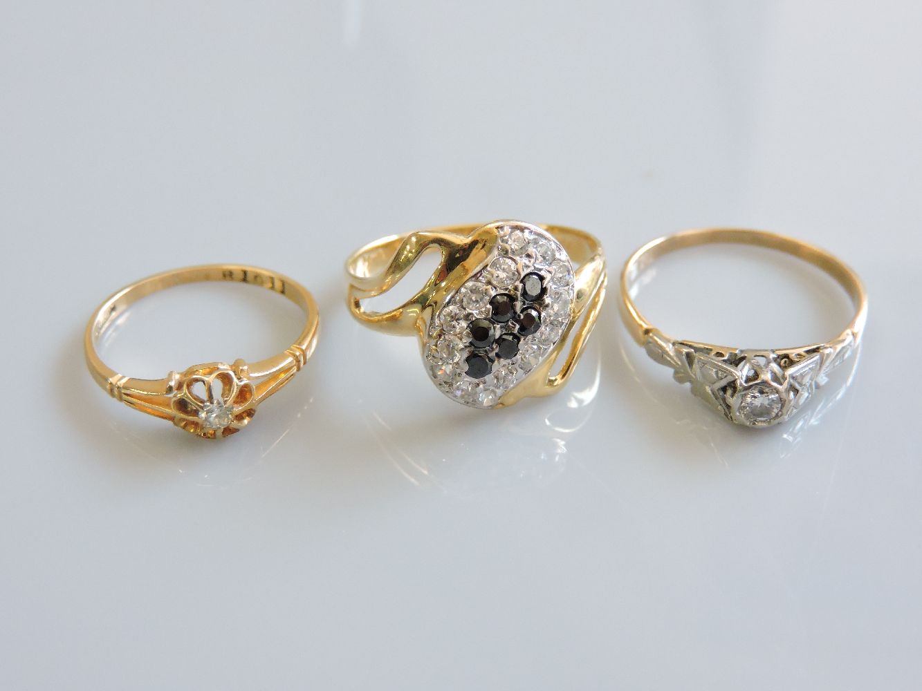 Two diamond rings, marked 18ct, and a cubic zirconia ring marked 750